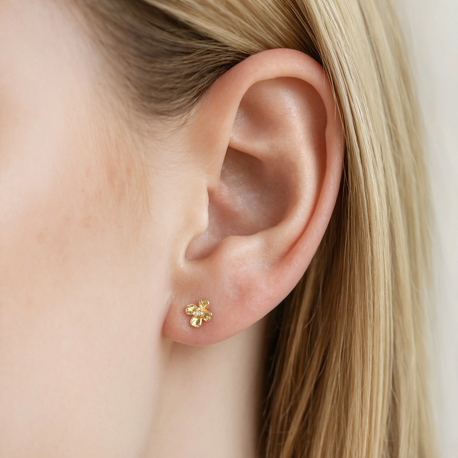 9ct gold flower studs in a models ear 