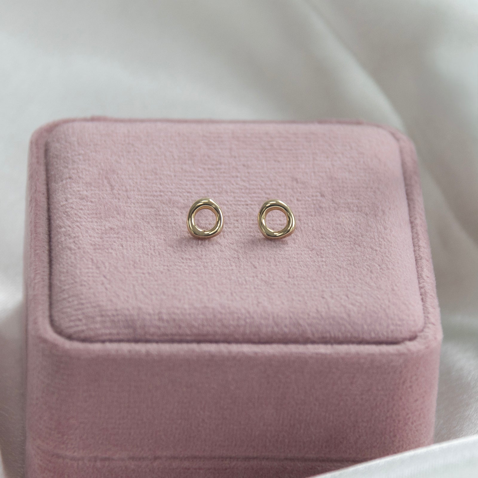 9 ct gold halo studs on a pink velvet box 