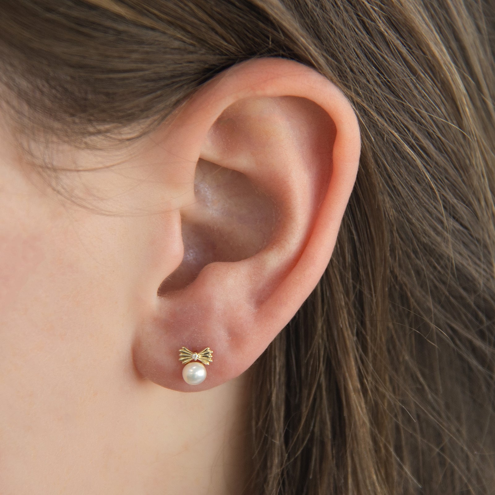 9ct gold pearl bow stud earrings in the ear