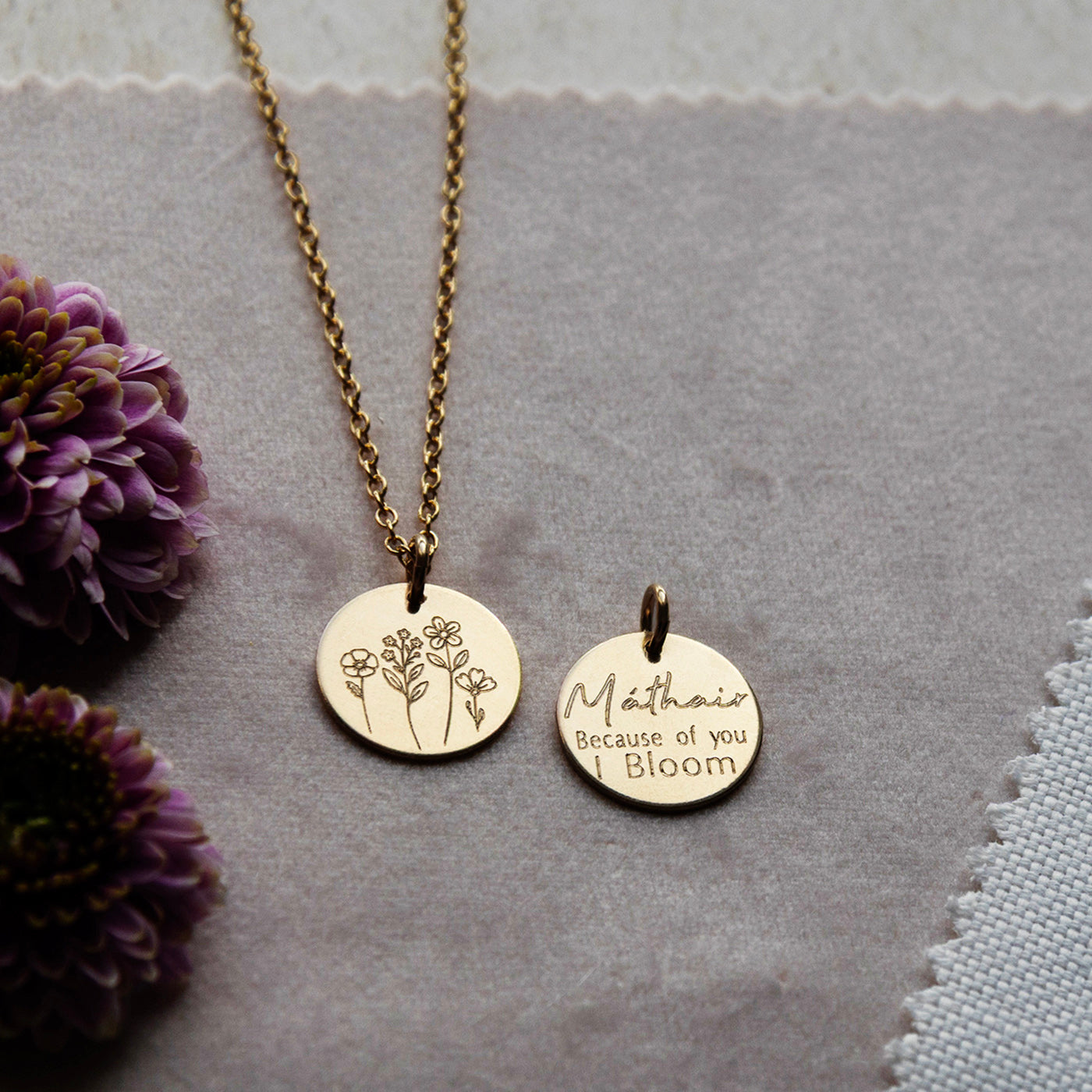 The Mathair Bloom Necklace styled in a flatlay on soft pink velvet fabric.
