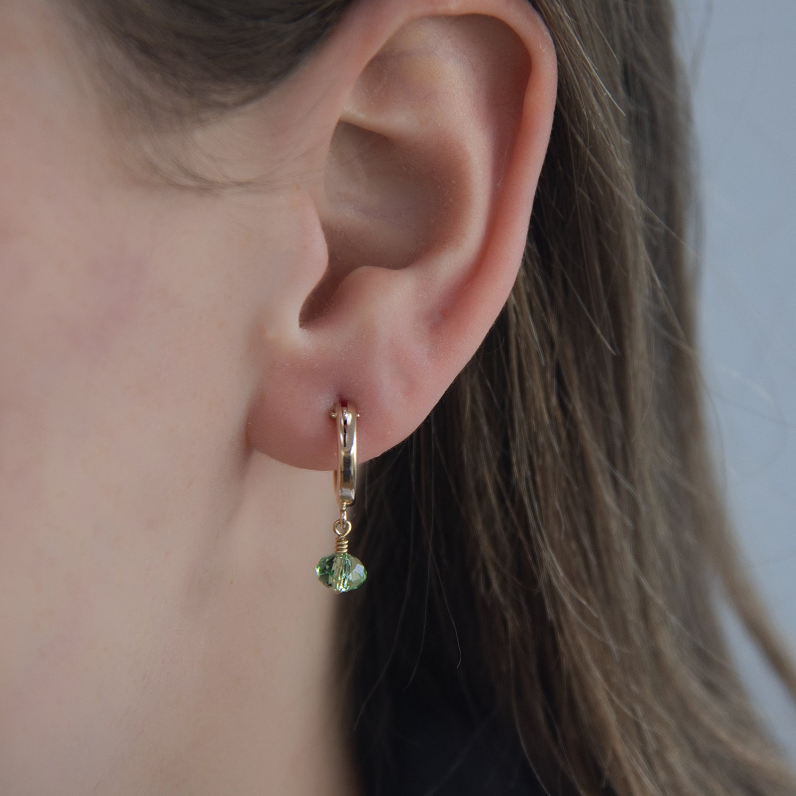 august birthstone earrings in the ear 