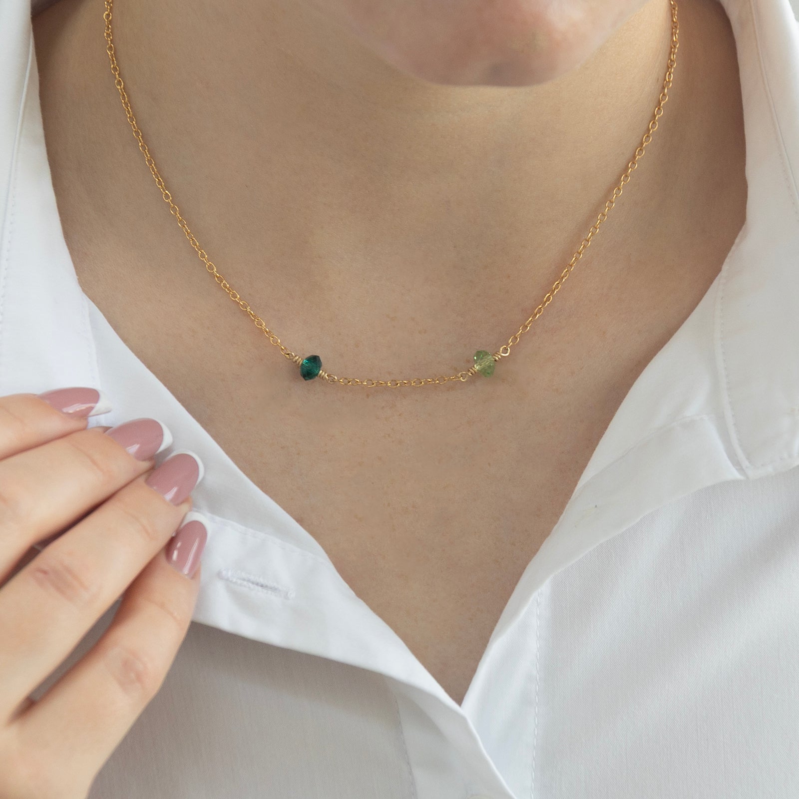 family birthstone necklace with two birthstones in gold shown close up on a model 