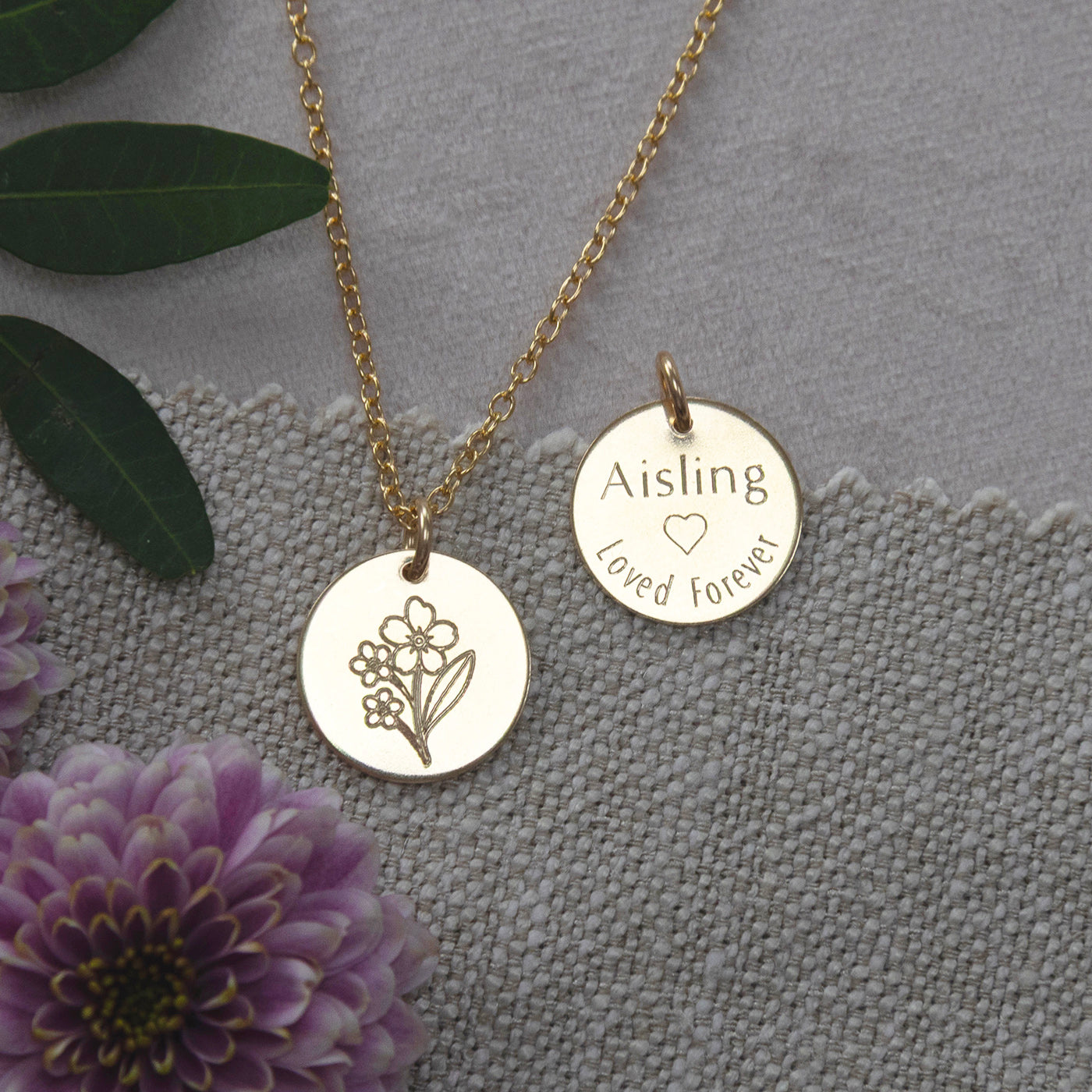 lifestyle image of forget me not memorial necklace front and back in gold 