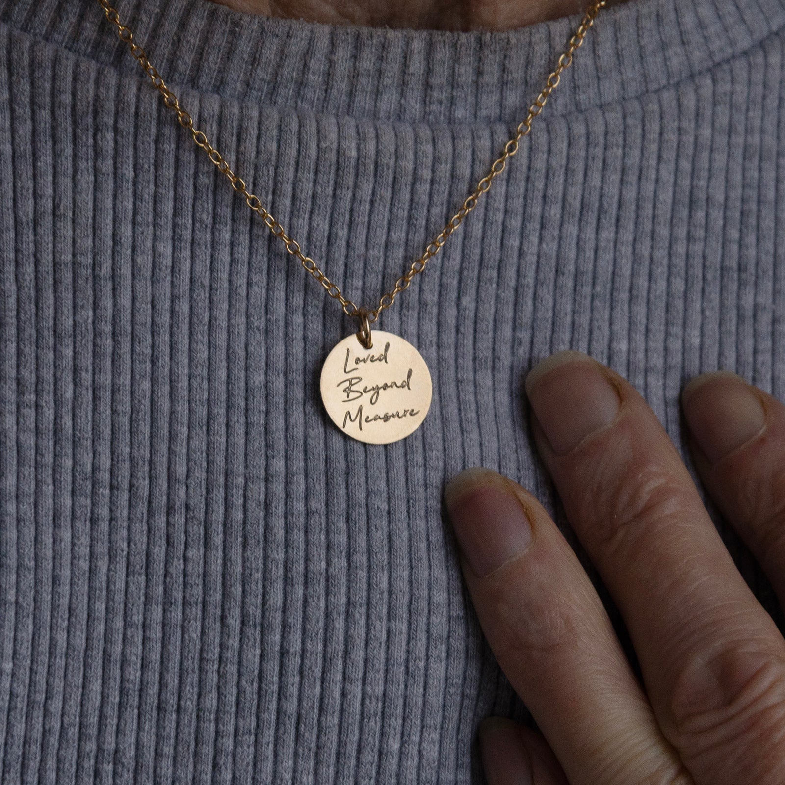 Back view of the personalised grandmother necklace worn on the neck of an older woman, shown in a close-up.